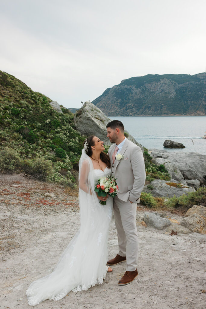 Outdoors island wedding ceremony, editorial photography, destination wedding at Agios Stephanos, Kastri island in KOS, Greece. Couple portraits at the island hills, with some green and ocean views.