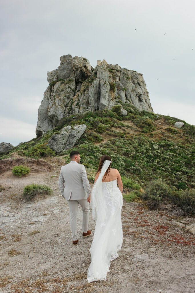 Outdoors island wedding ceremony, editorial photography, destination wedding at Agios Stephanos, Kastri island in KOS, Greece. Couple portraits at the island hills, with some green and ocean views.