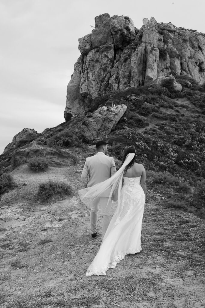 Outdoors island wedding ceremony, editorial photography, destination wedding at Agios Stephanos, Kastri island in KOS, Greece. Couple portraits at the island hills, with some green and ocean views.