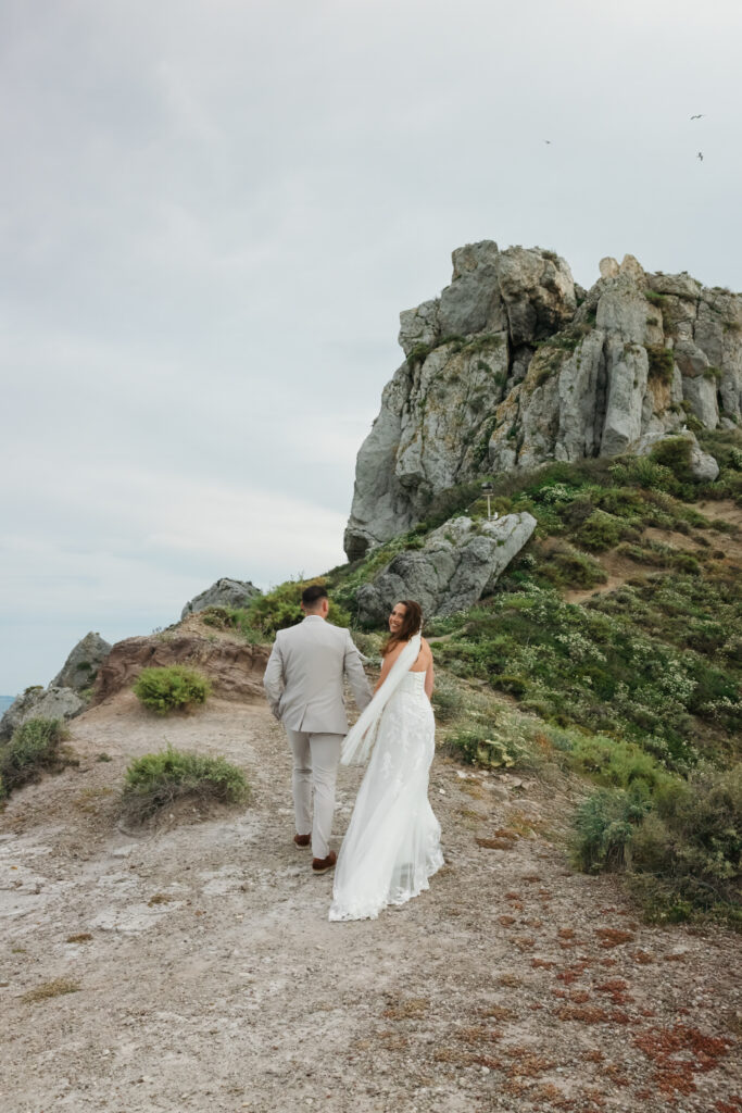 Outdoors island wedding ceremony, editorial photography, destination wedding at Agios Stephanos, Kastri island in KOS, Greece. Couple portraits at the island hills, with some green and ocean views.