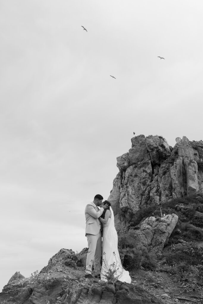 Outdoors island wedding ceremony, editorial photography, destination wedding at Agios Stephanos, Kastri island in KOS, Greece. Couple portraits at the island hills, with some green and ocean views.