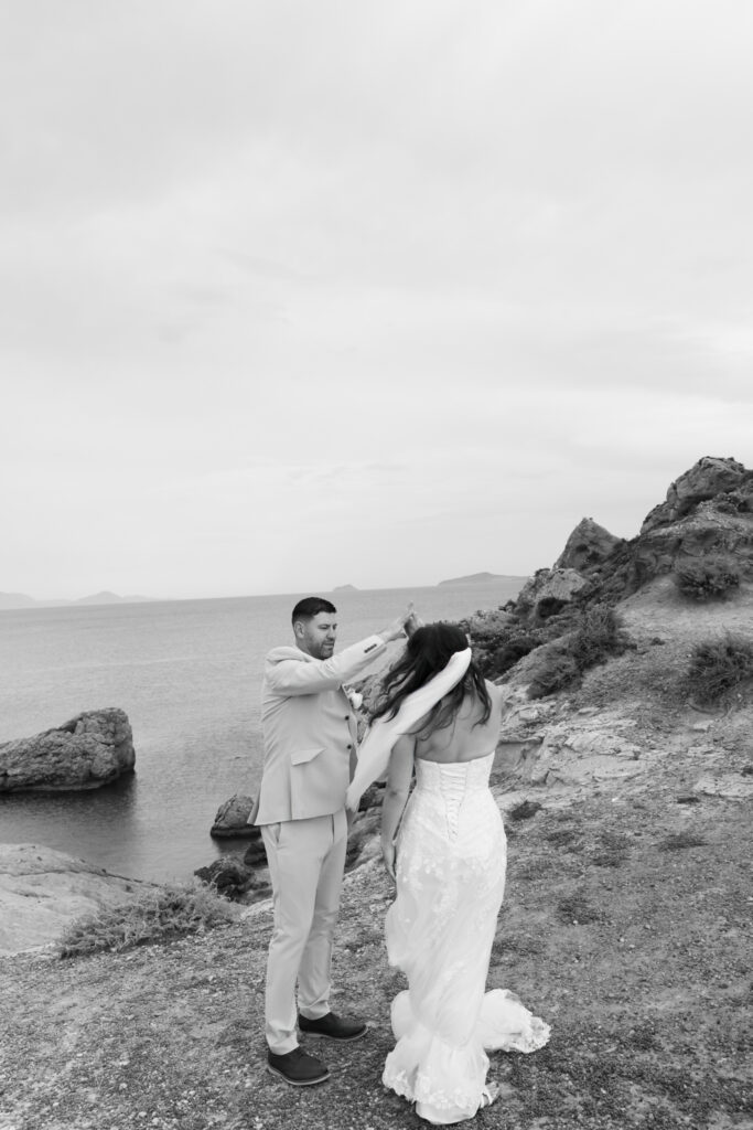 Outdoors island wedding ceremony, editorial photography, destination wedding at Agios Stephanos, Kastri island in KOS, Greece. Couple portraits at the island hills, with some green and ocean views.
