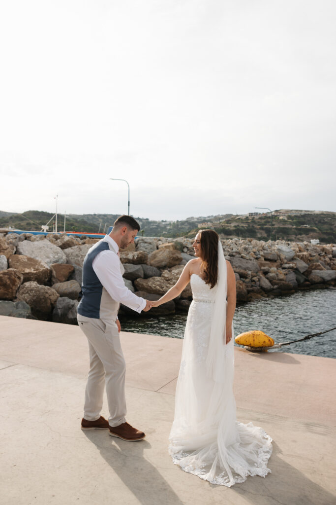 Outdoors island wedding ceremony, editorial photography, destination wedding at Agios Stephanos, Kastri island in KOS, Greece. Bride and groom couple photos by the pier.