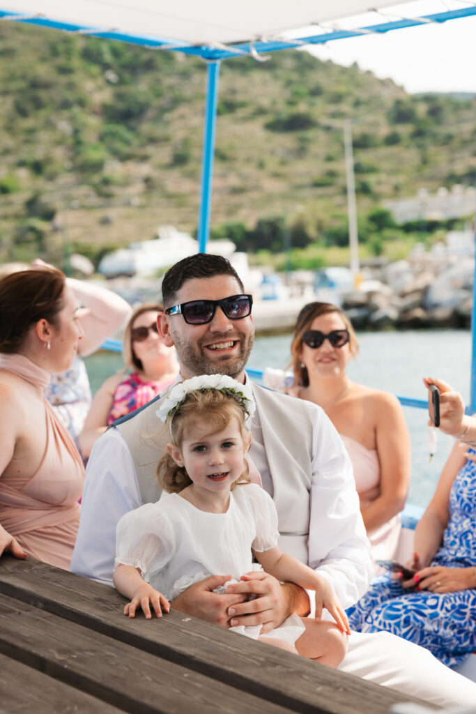 Wedding guests arriving by boat for outdoors island wedding ceremony, editorial photography, destination wedding at Agios Stephanos, Kastri island in KOS, Greece.