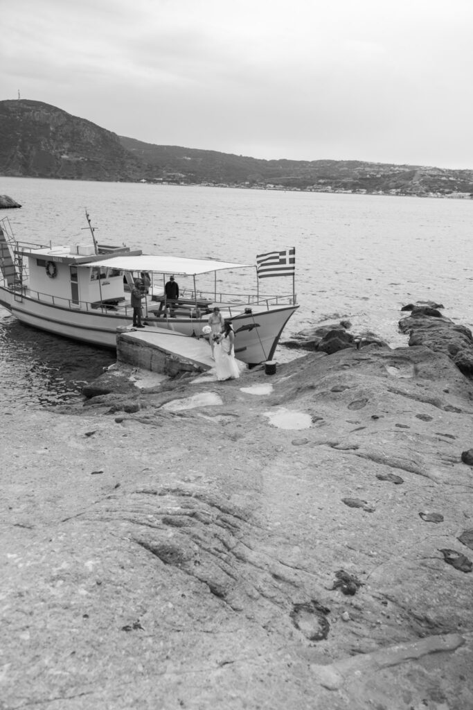 Bride arriving to the island by boat, editorial photography, destination wedding at Agios Stephanos, Kastri island in KOS, Greece.
