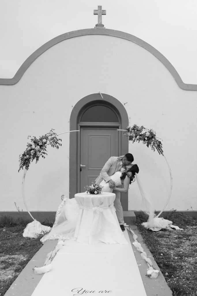 Outdoors island wedding ceremony, editorial photography, destination wedding at Agios Stephanos, Kastri island in KOS, Greece. Kiss dip.