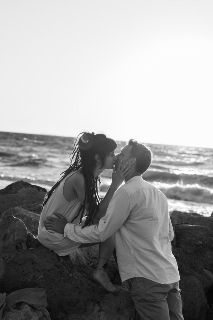 Romantic storytelling portrait of Greek and Italian couple walking barefoot on Kos beach at golden hour — destination wedding photographer Greece. Editorial photography, engagement beach sunset session.